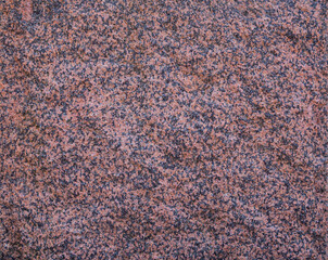 Close-up of natural red granite rock surface texture, front view. Abstract full frame textured background. Copy space.