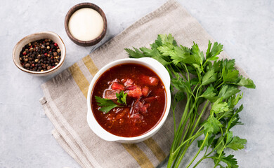 Traditional beetroot soup (Borscht) on light background with sour cream and fresh herb. Ukrainian and Russian national cuisine.