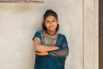 Portrait of a smiling asian Indian Girl standing and looking at camera isolated over white...