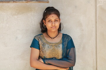 Portrait of a smiling asian Indian Girl standing and looking at camera isolated over white background.