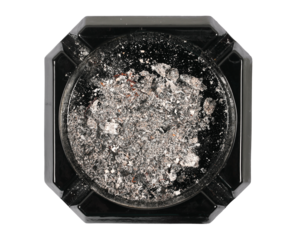 Black glass ashtray with cigarette ash isolated on white, top view