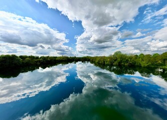 Obraz premium Picturesque view of a tranquil body of water with the sky reflecting in its surface.
