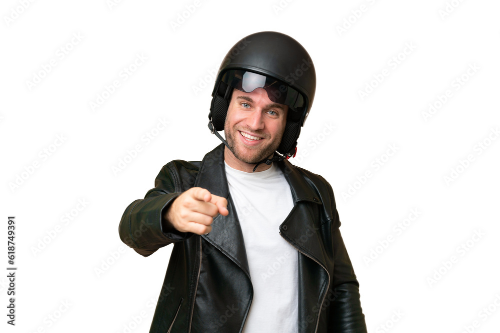 Sticker Young caucasian man with a motorcycle helmet isolated on green chroma background pointing front with happy expression