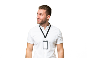 Young caucasian man with ID card isolated on green chroma background looking to the side and smiling