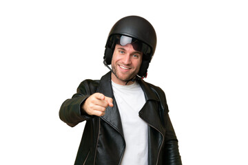 Young caucasian man with a motorcycle helmet isolated on green chroma background pointing front with happy expression