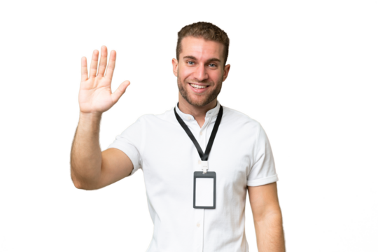 Young caucasian man with ID card isolated on green chroma background saluting with hand with happy expression