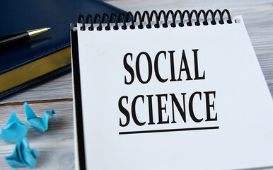 SOCIAL SCIENCE - words in a notebook on the background of a weekly and a pen.
