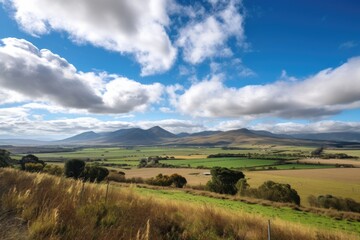 Fototapeta premium rolling countryside with towering range of clouds and blue sky in the distance, created with generative ai