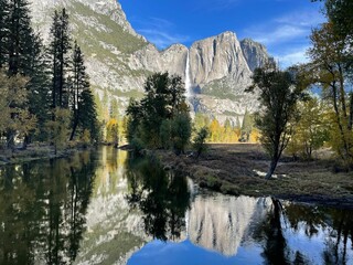 Naklejka premium Majestic Yosemite Valley surrounded by lush woodlands and towering mountain peaks