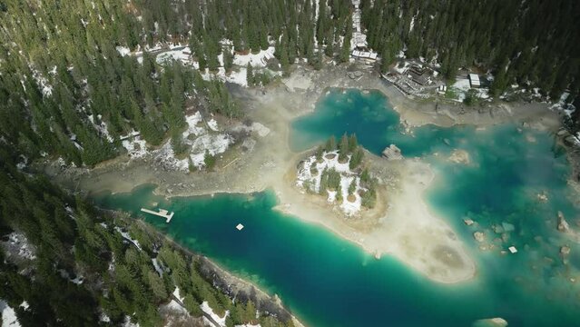 Drone view of turquoise Lake Cauma with forest trees with blue cloudy sky in Switzerland
