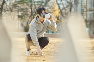Young college student male model wearing 3D glasses and experiencing virtual reality in an outdoor...