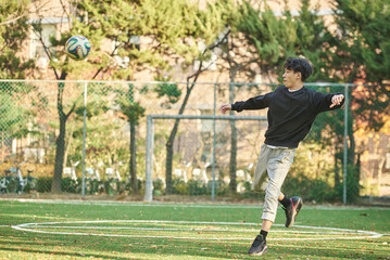 Asian Korean young male college athlete model controlling the ball with his feet and chest