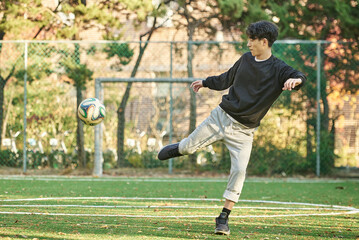 Asian Korean young male college athlete model controlling the ball with his feet and chest