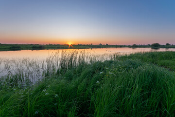 July sunrise over the lake 