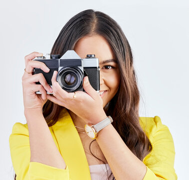 Creative, portrait and a woman with a camera for a photo, memory or career in photography. Happy, paparazzi and a young girl or photographer taking a picture isolated on a white background in studio