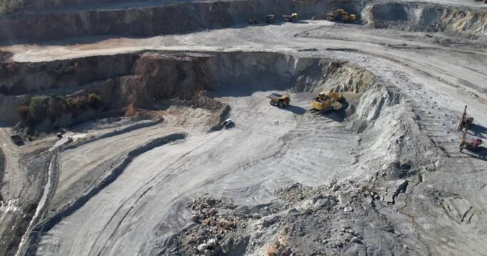 Production equipment escavators, dumper trucks for the extraction of iron ore in a quarry. The process of mining iron ore in a quarry.
