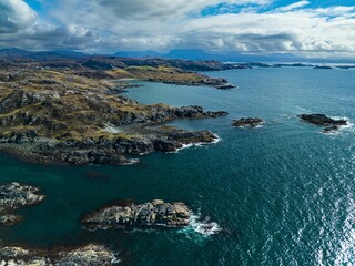 the blue water of a bay surrounded by hills and clouds