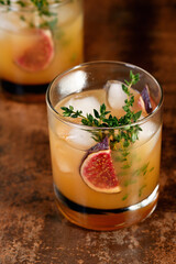  Bourbon Sour cocktail with fig spices, lemon juice and syrup. Easy to make but so delicious. Garnish with figs and thyme.