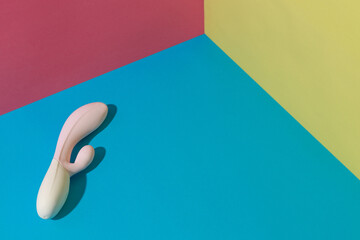 White dildo vibrator for satisfaction on colored background. Sex toy for adult. Sex shop concept