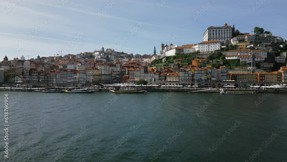 Wall mural drone footage of coastline by boats in porto, portugal with blue sky on the horizon