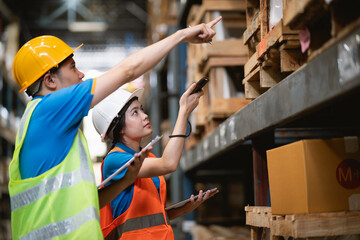 Young Asian woman worker using barcode scanner checking goods and box shelf stock in the warehouse...
