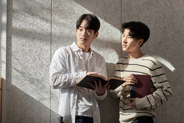 Young male college student models leaning against the wall of a university lecture hall in a light-filled room in South Korea, Asia