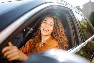 Smiling woman driving a car. Young traveler driving. Car travel, lifestyle concept.