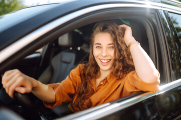 Smiling woman driving a car. Young traveler driving. Car travel, lifestyle concept.