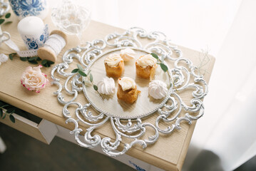 Delicious sweets on a beautiful silver glass tray on the table. Candy bar at a wedding or party