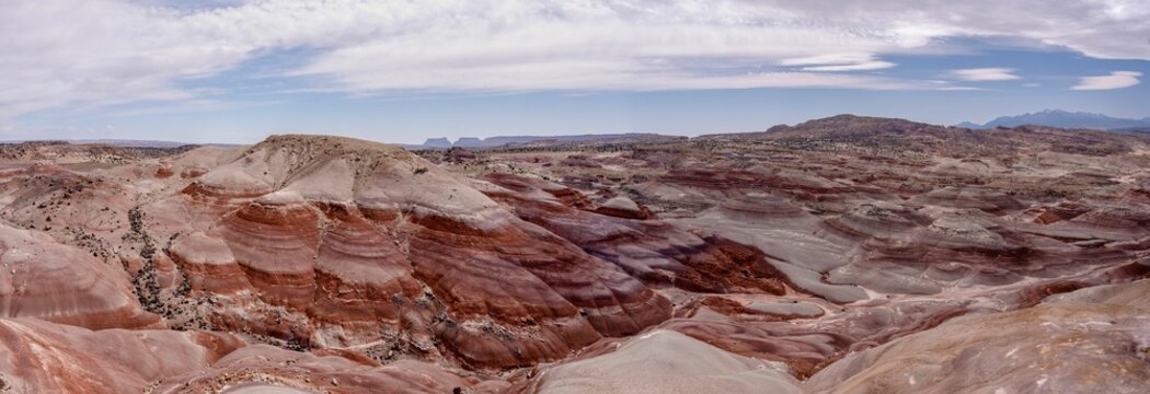Scenic desert landscape with hills and a bright blue sky with white clouds scattered throughout