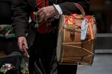 Fototapeta premium Close-up shot of an elderly Maragato gentleman carrying a drum while in traditional attire