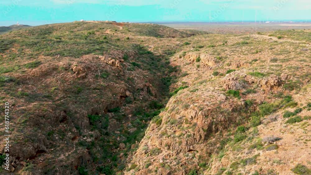 Poster aerial footage of range hill fields with holes and blue sky on the horizon