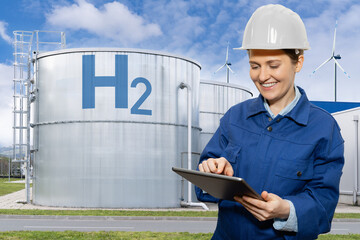 Woman engineer with tablet computer on a background of Hydrogen factory.