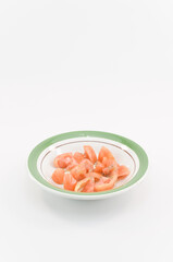 immagine con piatto contenete pomodori tagliati a cubetti conditi con olio d'oliva e origano, superficie bianca