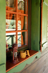 Traditional Finnish wooden mug kuksa and vintage lantern on the window