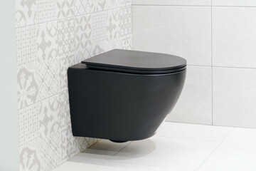 Black wall hung toilet in the bathroom. Wall-hung WC without flush rim - Dirt and germs hardly have...