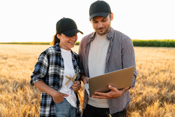 Couple of farmers examines the field of cereals.