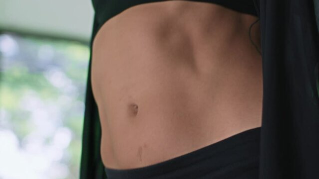 Female dancer makes body movement while practicing modern choreography in studio. Attractive woman in black clothes sensually and sexually dances with her hands and belly