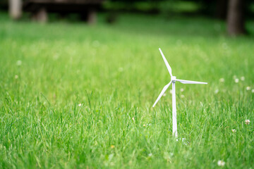Toy wind turbine on grass.