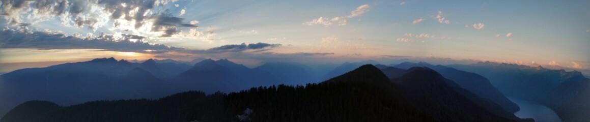 Mesmerizing panoramic view of a winter scene of snow-capped mountains and evergreen pine trees