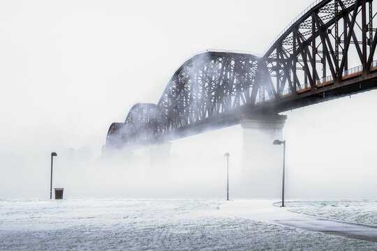 Scenic bridge stretched over the Ohio river with fog hovering over it.