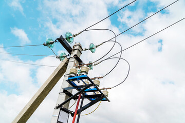 Power lines. A fragment of a concrete pole and electrical wires against the background of clouds...