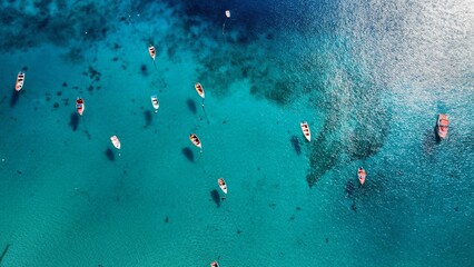 Aerial shot of a number of boats leisurely sailing in the magnificent blue waters of a tranquil bay.
