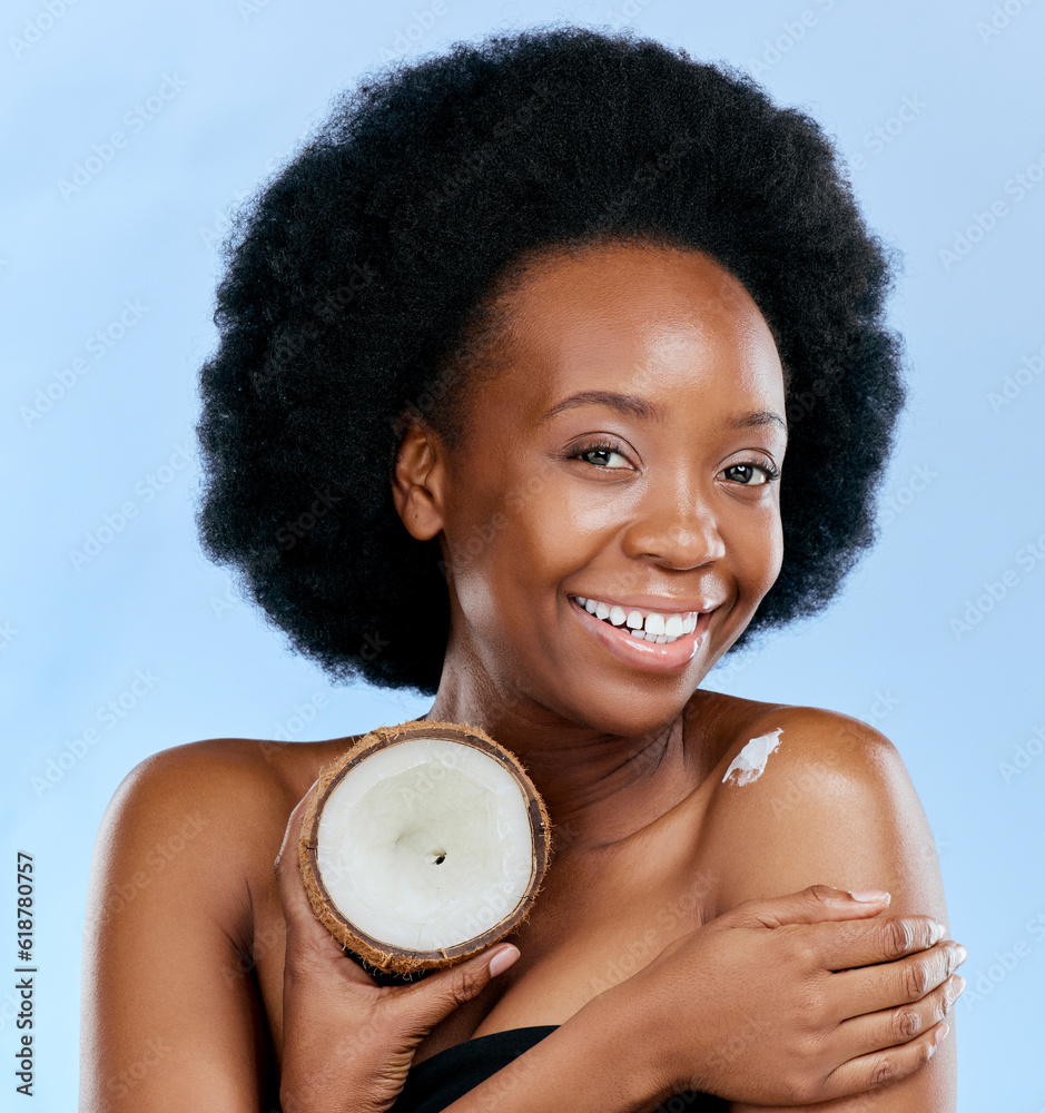 Canvas Prints Portrait, body and coconut with a model black woman in studio on a blue background for natural treatment. Beauty, skincare and smile with a happy young female person holding fruit for cosmetic oil