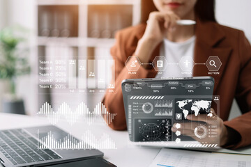 Businesswomen using tablet with laptop and document on desk in modern office with virtual interface graphic icons network diagram.