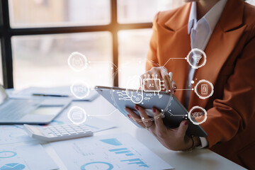 AI or Artificial Intelligence technology. Businessman using a tablet and laptop computer chatting with an intelligent artificial intelligence. Futuristic technology, automate Chat Bot, Smart Ai.