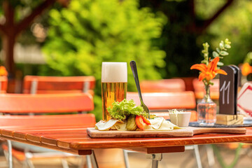 View at a typical bavarian lunch in a beer garden in summer outdoors, regional delicacy during...