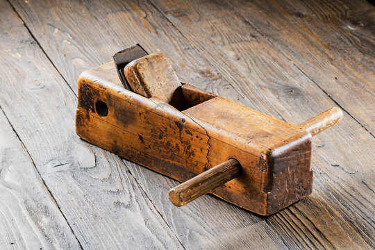 Old planer with signs of wear and age on a dark wooden background