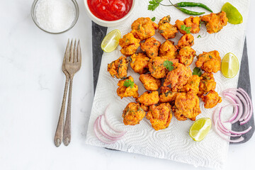 Indian Chicken Pakora / Fritters with Ketchup, Green Chillies, Lemon and Onion Top Down Photo