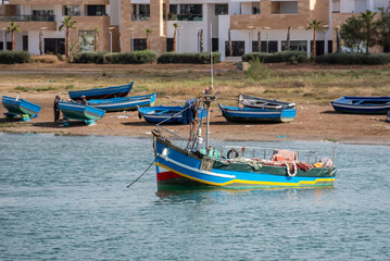 Fototapeta na wymiar An traditionally painted small fisher boat in the harbor of Rabat